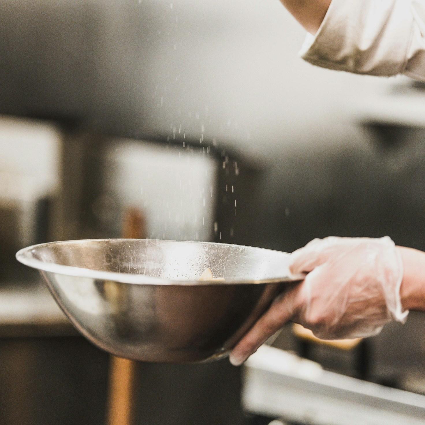 Community members collaborating in a modern kitchen space, sharing recipes and cooking techniques